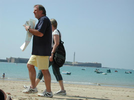 Tourists in shorts walking along the city beach, Cadiz