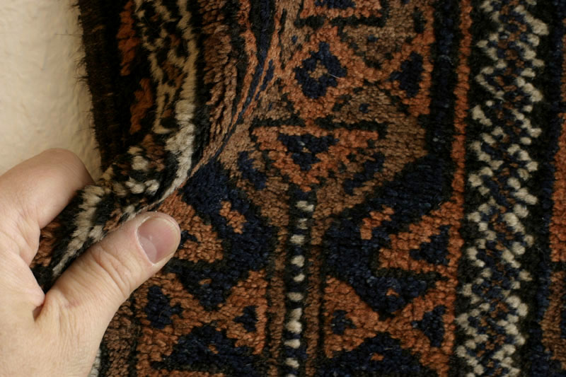 Small antique Khorassan Baluch rug with endless repeat diamond and flower design, pile fold