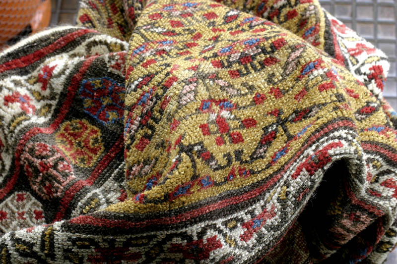 Antique Kurdish rug, end of 19th c., shrubs on yellow ground: folds