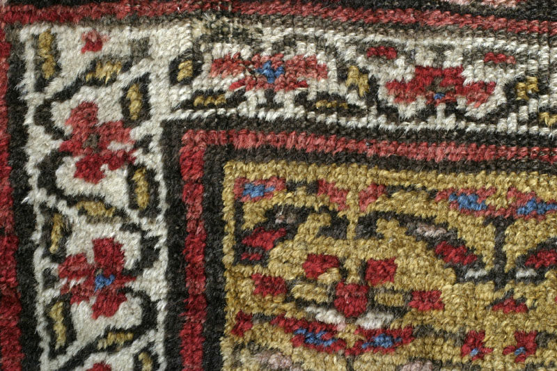 Antique Kurdish rug, end of 19th c., shrubs on yellow ground: top left corner